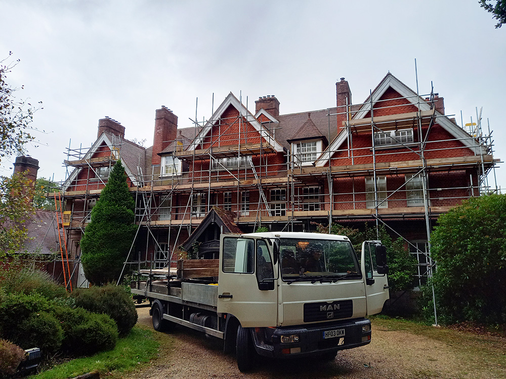 Large house undergoing construction work with scaffolding to front